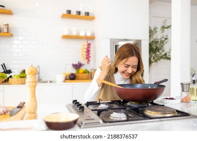 Young Beautiful Asian Woman Enjoy Cooking Healthy Food And Pasta In Cooking Pan On Stove In The Kitchen At Home. Happy Female Having Dinner Meeting Party Celebration With Friends On Holiday Vacation.