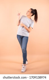 Young Beautiful Asian Woman / Girl Happy Pointing To Above Copy Space Isolated Over Blank Background, Studio Shot, Full-length, Full Body