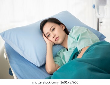 Young Beautiful Asian Woman Lying On The Bed In Hospital, She Have Problem With Her Health Mental And Sadness From Bipolar Disorder. Background - Copy Space. 