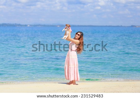 a young beautiful asian woman playing with the puppy on the beach, Munnork island, Rayong, Thailand