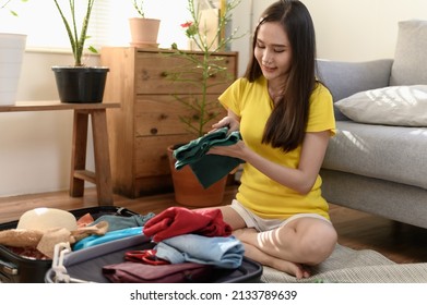 Young Beautiful Asian Woman Preparing And Arrange Clothes Personal Belonging And Equipment Before Go Travel Oversea After Covid Pandemic. New Normal Travel Lifestyle Concept.