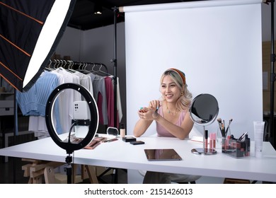 Young beautiful Asian woman and professional beauty make up artist vlogger or blogger recording makeup tutorial to share on website or social media. Business online influencer on social media concept. - Powered by Shutterstock