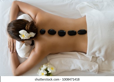 Young beautiful Asian woman relaxing in the Spa Stone Massage. Spa Hot Stones