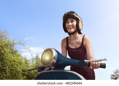 Young Beautiful Asian Woman Riding Scooter On The Street