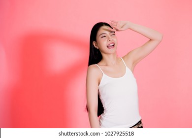 Young beautiful Asian woman scared of sunshine isolated over pink background. Concept for summer skin care and skin protection from uv sunshine