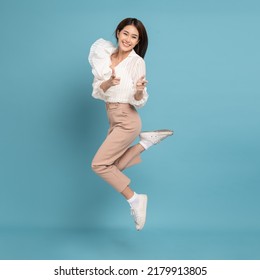 Young beautiful asian woman with smart casual cloth jumping and smiling with excitement pointing at camera isolated on blue background - Shutterstock ID 2179913805