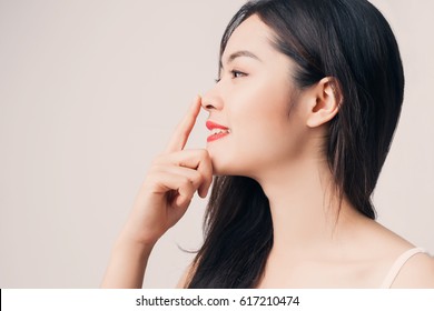 Young Beautiful Asian Woman With Smiley Face And Red Lips Touching Her Nose.