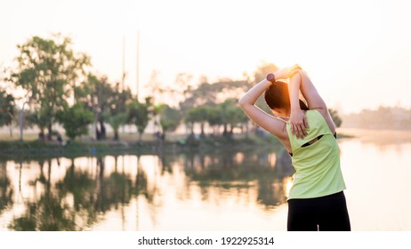 Young Beautiful Asian Woman In Sports Outfits Doing Stretching Before Workout Outdoor In The Park In The Morning To Get A Healthy Lifestyle. Healthy Young Woman Warming Up Outdoors.