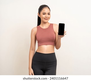Young beautiful asian woman with sportswear using smartphone on isolated white background. Attractive Portrait latin sporty woman standing pose holding cell phone exercise workout in studio.