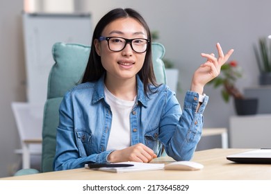 Young Beautiful Asian Woman Talking On Video Call, Business Woman Working In Modern Office, Smiling And Looking At Web Camera, Online Conference.