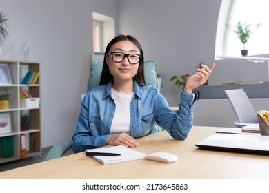 Young Beautiful Asian Woman Talking On Video Call, Business Woman Working In Modern Office, Smiling And Looking At Web Camera, Online Conference.