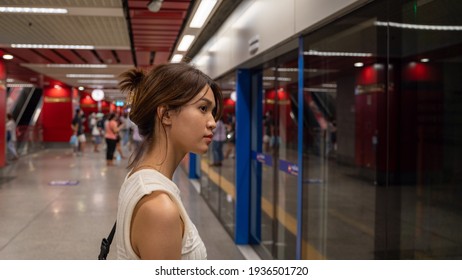 Young Beautiful Asian Woman Traveler Waiting For Transportation Underground In Bangkok Subway MRT In Thailand, White Sleeveless Shirt, Train, Girl,  Railway Station.