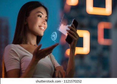 A Young Beautiful Asian Woman Using Innovative Technologies As An Application In Her Smart Phone To Monitor Sales Analytics. Communicate About Business, Future, Technology, Statistics, Data, People