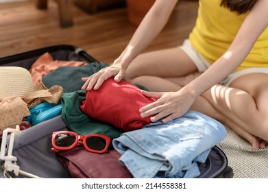 Young Beautiful Asian Woman Using Checklist Prepare Arrange Clothes And Equipment Before Go Travel Oversea After Covid Pandemic. New Normal Travel Lifestyle Concept.