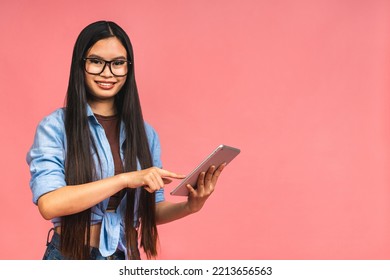 Young Beautiful Asian Woman Using Tablet Gadget Ipad Computer. Lifestyle Concept. Isolated On Pink Background.
