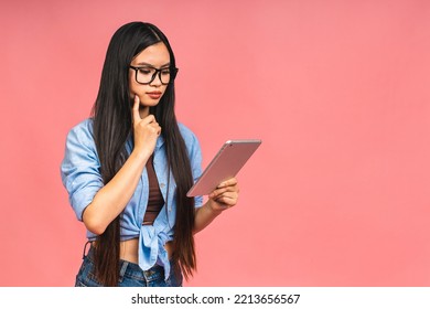 Young Beautiful Asian Woman Using Tablet Gadget Ipad Computer. Lifestyle Concept. Isolated On Pink Background.