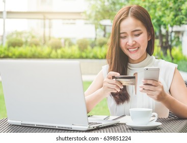 Young Beautiful Asian Woman Using Credit Card And Laptop For Online Shopping At Outdoor Park, Smile/fresh And Happy Feeling In The Morning, Freelancer Businesswoman Lifestyle Concept