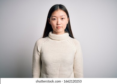 Young Beautiful Asian Woman Wearing Casual Sweater Standing Over Isolated Background Relaxed With Serious Expression On Face. Simple And Natural Looking At The Camera.