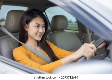 Young Beautiful Asian Women Getting New Car. She Very Happy And Excited. She Sit And Touching Every Detail Of Car. Smiling Female Driving Vehicle On The Road