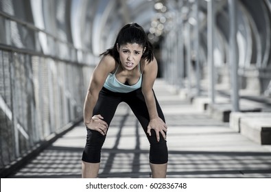 Young Beautiful And Athletic Sport Woman Tired And Exhausted Breathing And Cooling Down After Running In Urban Training Workout On Modern Metal City Bridge In Female Runner Body Care Concept