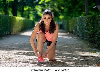 Young Beautiful And Attractive Latin Sport Runner Woman Tying Her Shoe Sneaker Laces Smiling Happy Ready For Running And Jogging Workout At City Forest Park In A Beautiful Autumn Morning