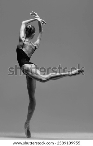 Young beautiful ballet dancer is posing in studio