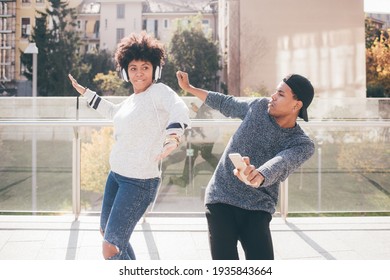 Young Beautiful Black Couple Dancing Outdoor Listening Streaming Music Having Fun Together