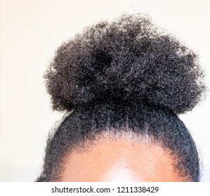 Young beautiful black girl with natural Afro Kinky hair bun on white background. African woman with cute bun for creative elegant salon hairstyles  for healthy afro hair concept