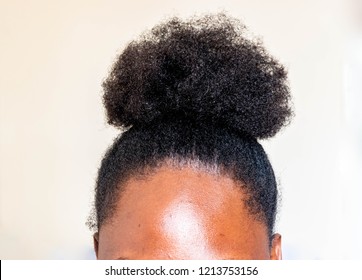 Young beautiful black girl with natural African American Kinky curly hair bun. African woman with cute bun for creative elegant hairstyles on white background for healthy afro hair concept