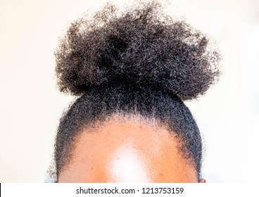 Young beautiful black girl with natural Afro Kinky hair bun. African woman with cute bun for creative elegant hairstyles on white background for healthy afro hair concept