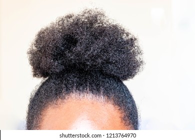 Young beautiful black girl with natural Afro Kinky hair bun. African American Kinky curly woman with cute bun for creative elegant hairstyles on white background for healthy hair concept