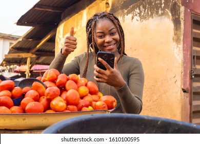 Young Beautiful Black Market Woman Using Her Mobile Phone In The Market