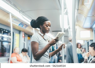 Young Beautiful Black Woman Sitting On Subway Reading A Book - Commuter, Student, Knowledge Concept