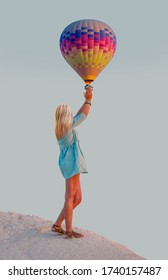 Young Beautiful Blond Girl Is Trying To Catch The Hot Air Baloon - Cappadocia, Turkey