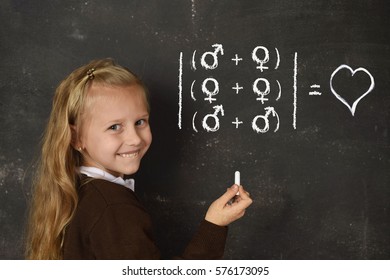 young beautiful blond sweet schoolgirl in uniform holding chalk writing on blackboard standing for freedom of sexuality orientation supporting love for heterosexual and homosexual couples