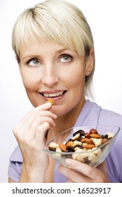 Young Beautiful Blond Woman Eating Nuts Close Up