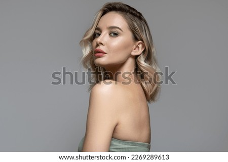 Young beautiful blond woman with hair and makeup. Clean skin. Facial, body and hair care