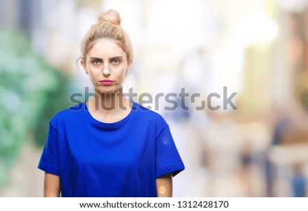 Young beautiful blonde and blue eyes woman wearing blue t-shirt over isolated background skeptic and nervous, frowning upset because of problem. Negative person.