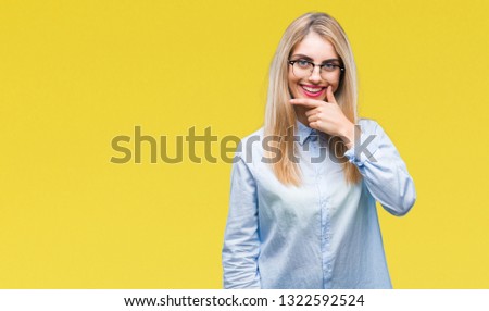 Young beautiful blonde business woman wearing glasses over isolated background looking confident at the camera with smile with crossed arms and hand raised on chin. Thinking positive.