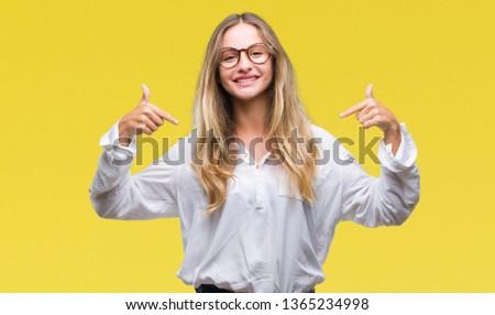 Young beautiful blonde business woman wearing glasses over isolated background looking confident with smile on face, pointing oneself with fingers proud and happy.