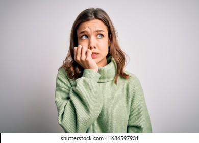 Young beautiful blonde girl wearing winter sweater standing over isolated background looking stressed and nervous with hands on mouth biting nails. Anxiety problem.