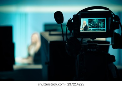 Young Beautiful Blonde Television Announcer At Studio During Live Broadcasting.Female TV Director At Editor In Studio.Recording At TV Studio With Television Anchorwoman. TV NEWS Studio With Camera 