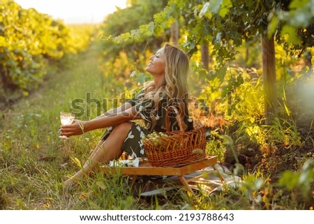 Young beautiful blonde woman on a picnic in the vineyards