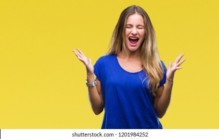 Young beautiful blonde woman over isolated background celebrating mad and crazy for success with arms raised and closed eyes screaming excited. Winner concept - Shutterstock ID 1201984252