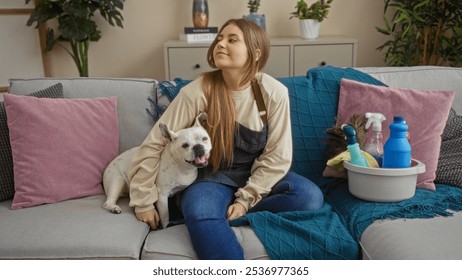 Young beautiful blonde woman sitting in a cozy living room with her dog on the sofa, surrounded by cleaning supplies. - Powered by Shutterstock