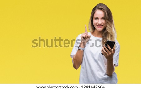 Young beautiful blonde woman using smartphone over isolated background surprised with an idea or question pointing finger with happy face, number one
