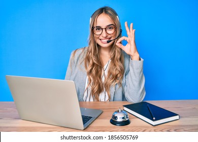 Young Beautiful Blonde Woman Wearing Operator Headset At The Call Center Office Doing Ok Sign With Fingers, Smiling Friendly Gesturing Excellent Symbol 