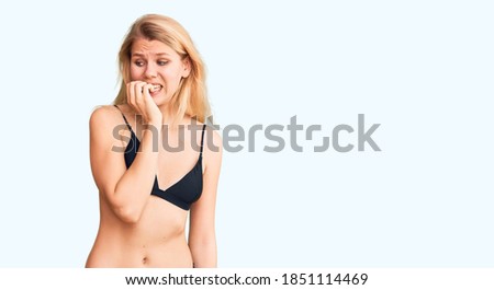 Young beautiful blonde woman wearing bikini looking stressed and nervous with hands on mouth biting nails. anxiety problem. 