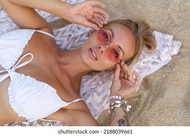 Young Beautiful Blonde Woman In White Cute Bikini, Orange Stylish Glasses And Lace Cape Posing On Beach,soft Natural Life, Romantic, Tender, Woman In Good Shape, Slim, Sporty