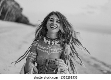 young beautiful boho woman portarait with traditional ornament on the beach at sunset